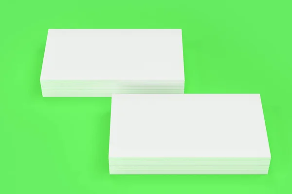 Tarjetas de visita blancas en blanco maqueta sobre fondo verde —  Fotos de Stock