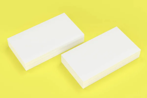 Tarjetas de visita blancas en blanco maqueta sobre fondo amarillo — Foto de Stock