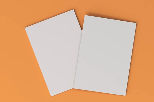 Dos blanco en blanco folleto cerrado maqueta sobre fondo naranja — Foto de Stock