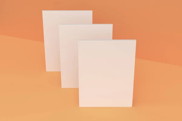 Drei weiße Broschüren-Attrappen auf orangefarbenem Hintergrund — Stockfoto