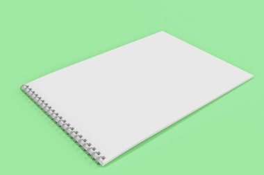 Yeşil arka plan üzerinde beyaz boş defter metal spiral ile bağlı
