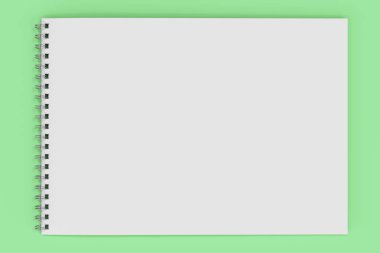 Yeşil arka plan üzerinde beyaz boş defter metal spiral ile bağlı