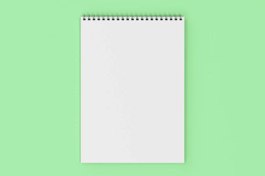 Yeşil arka plan üzerinde beyaz boş defter metal spiral ile bağlı