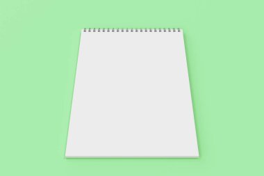 Yeşil arka plan üzerinde beyaz boş defter metal spiral ile bağlı