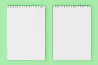 Yeşil arka plan üzerinde beyaz boş defter metal spiral ile bağlı