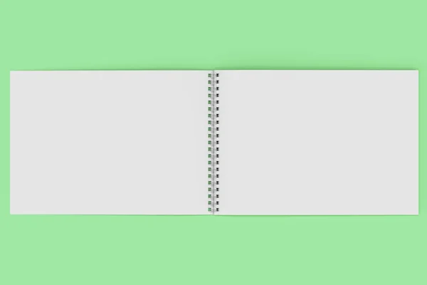 Відкрити порожній білий блокнот з металевою спіраллю, прив'язаною на зеленому фоні — стокове фото