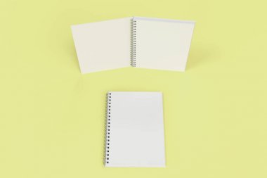 Sarı arka plan üzerinde iki defter spiral ile bağlı