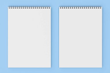 Üzerinde mavi arka plan beyaz boş defter metal spiral ile bağlı