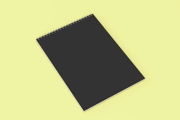 पीले पृष्ठभूमि पर बंधे धातु सर्पिल के साथ खाली काले नोटबुक — स्टॉक फ़ोटो, इमेज