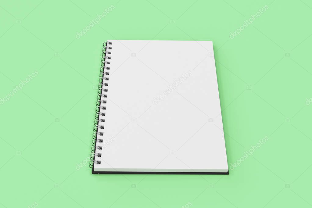 Opend notebook spiral bound on green background