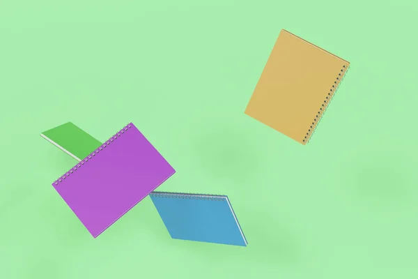 Четыре ноутбука со спиралью на зеленом фоне — стоковое фото