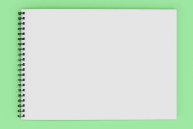 Yeşil arka plan üzerinde beyaz boş defter siyah sarmal ile bağlı