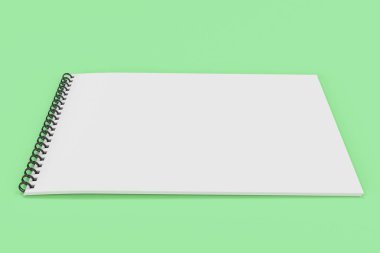 Yeşil arka plan üzerinde beyaz boş defter siyah sarmal ile bağlı