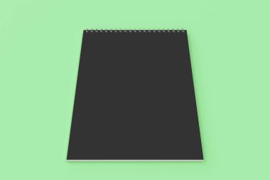 Yeşil arka plan üzerinde boş siyah defter metal spiral ile bağlı