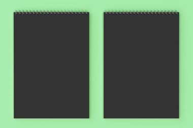 Yeşil arka plan üzerinde boş siyah defter metal spiral ile bağlı