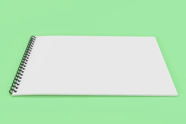 Порожній білий блокнот з чорною спіраллю, прив'язаною на зеленому фоні — стокове фото