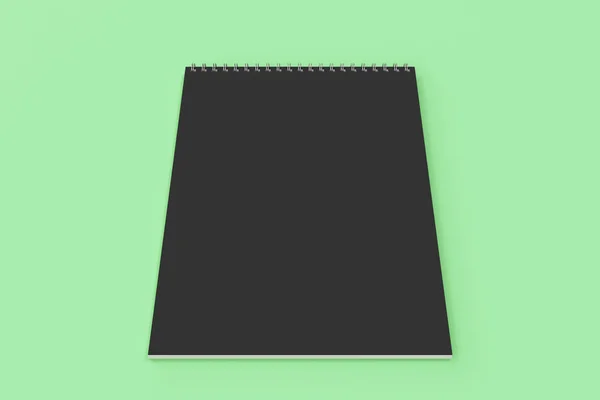 Порожній чорний блокнот з металевою спіраллю, прив'язаною на зеленому фоні — стокове фото