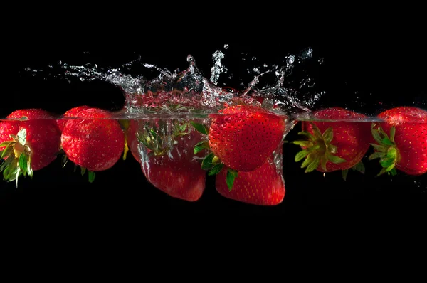 Erdbeeren, die ins Wasser spritzen — Stockfoto