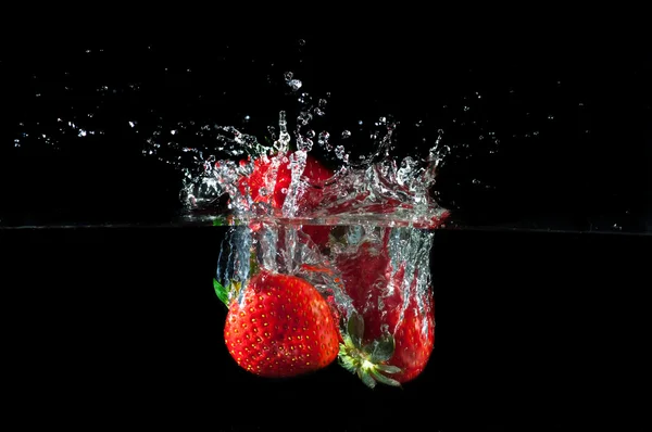 Fragole che schizzano in acqua — Foto Stock