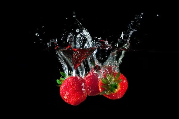 Fragole che schizzano in acqua — Foto Stock