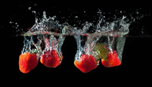 Fragole che schizzano in acqua — Foto Stock