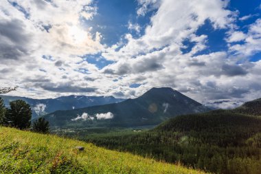 bulutlar dağlar ve ağaçlar üzerinde