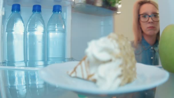 Jovem abre a geladeira e furtivamente comer bolo enquanto ninguém a vê — Vídeo de Stock