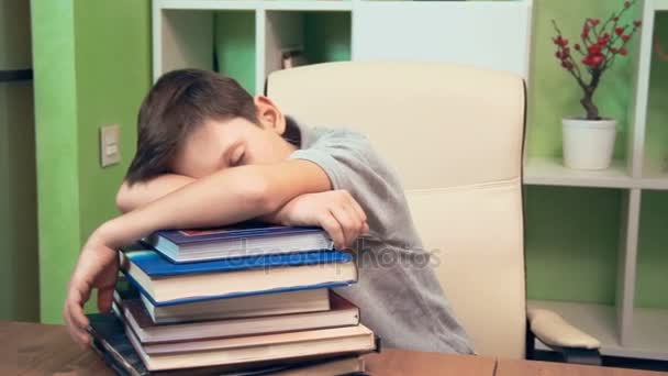 Menino dormindo em uma pilha de livros — Vídeo de Stock