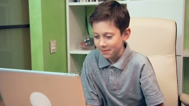 Smiling little boy wating video on the laptop computer — Stock Video