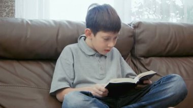 Küçük çocuk kitap okuyor.