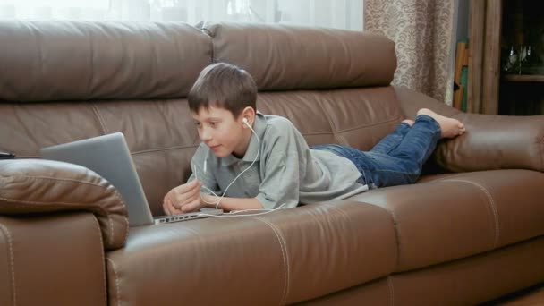 Menino assistindo vídeo no computador portátil — Vídeo de Stock