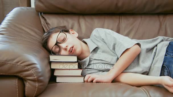 Lille pojken sover på högen av böcker — Stockvideo