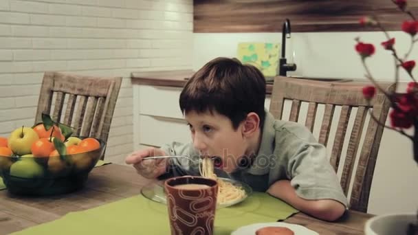 Niño comiendo pasta en la cocina — Vídeos de Stock