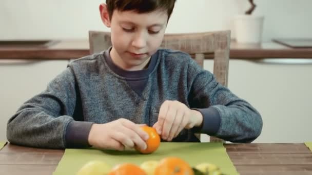 Rapaz a descascar uma tangerina — Vídeo de Stock
