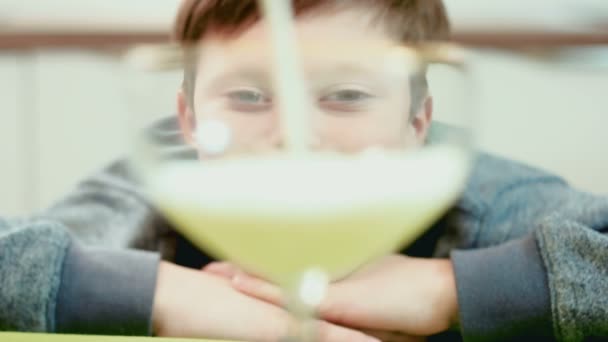 Мальчик смотрит на налитое молоко в стакан. — стоковое видео
