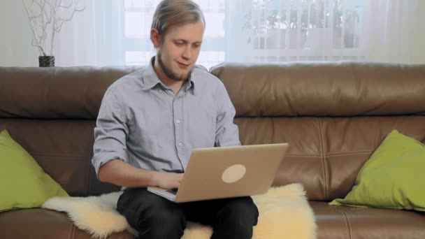 Joven escribiendo en su computadora portátil — Vídeo de stock