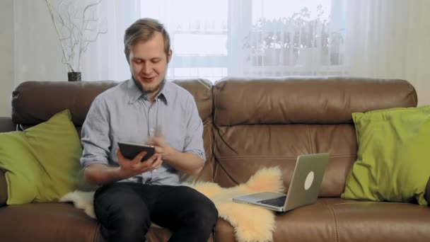 Joven hombre de negocios con una tableta digital diciendo buenas noticias a la cámara — Vídeos de Stock