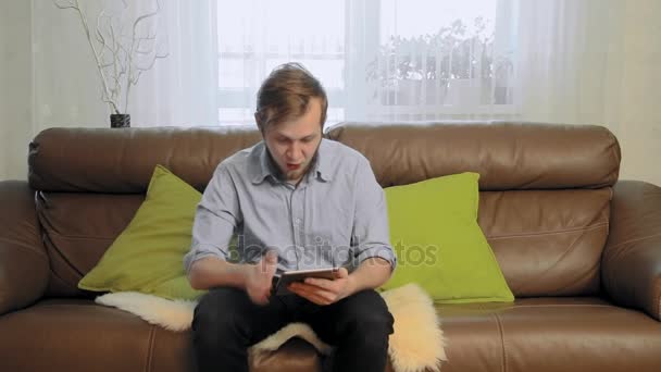 Joven usando una tableta tiene un éxito y celebrando — Vídeos de Stock