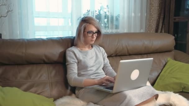 Jovem mulher trabalhando em seu computador portátil e está chocada — Vídeo de Stock