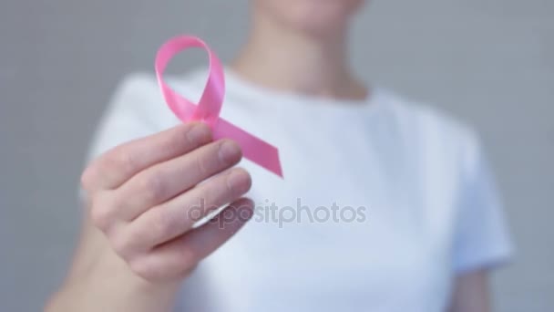 Mujeres manos sosteniendo rosa cáncer de mama conciencia cinta -concepto de conciencia de cáncer de mama — Vídeos de Stock