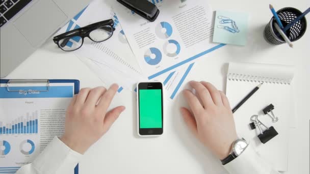 Pebisnis top view duduk di meja kantor tangan dekat layar hijau ponsel pintar — Stok Video