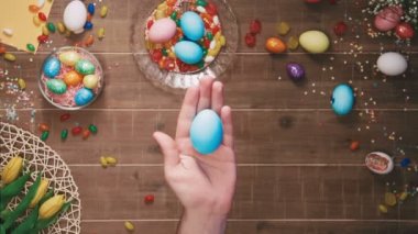 Paskalya yortusu yumurta Paskalya yumurtaları ile dekore edilmiş tablo önünde tutan el. Üstten Görünüm