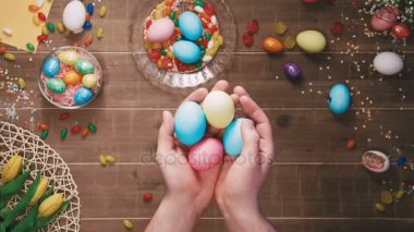 Paskalya yumurtaları masanın önünde tutan eller Paskalya yumurtaları ile dekore edilmiştir. Üstten Görünüm