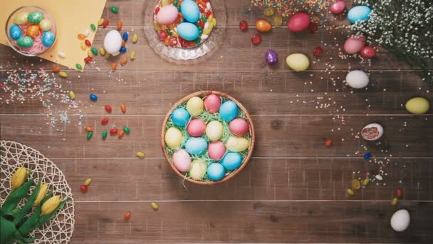 Uomo che prende cesto con uovo di Pasqua dal tavolo decorato con uova di Pasqua. Vista dall'alto — Video Stock