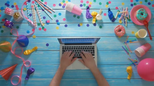 Bovenaanzicht man planning van de verjaardagspartij laptopcomputer gebruikt — Stockvideo