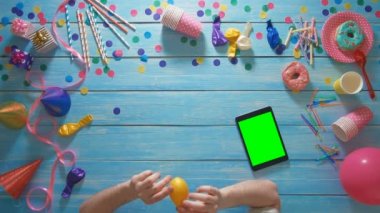 Üstten Görünüm adam doğum günü ballon, dijital tablet ile masada Yeşil perde açılırsa