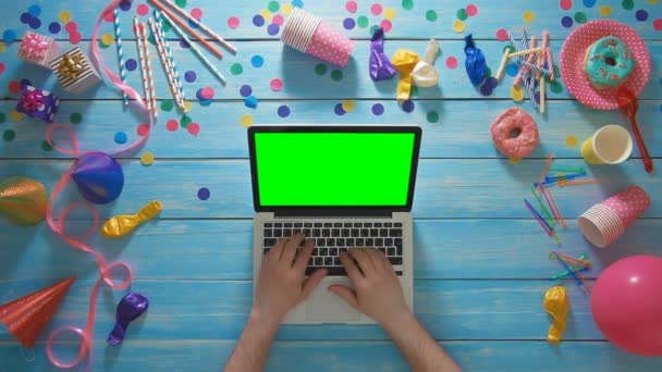 Üstten Görünüm adam dizüstü bilgisayar yeşil ekran kullanarak doğum günü partisi planlama — Stok video