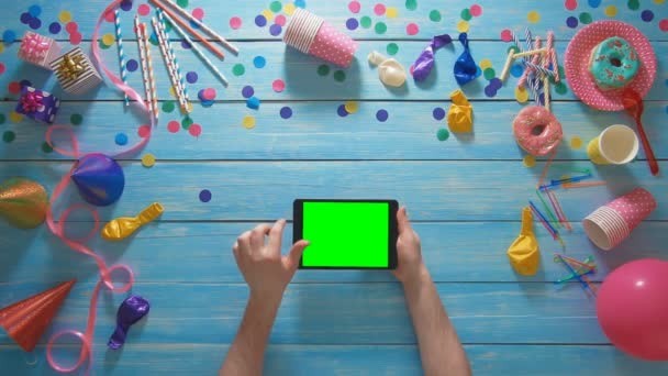 Вид зверху чоловік планує вечірку на день народження за допомогою цифрових жестів планшетів з зеленим екраном — стокове відео