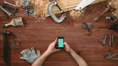 Üstten Görünüm usta gösteren multitouch jestleri ile yeşil perde smartphone üzerinde eller