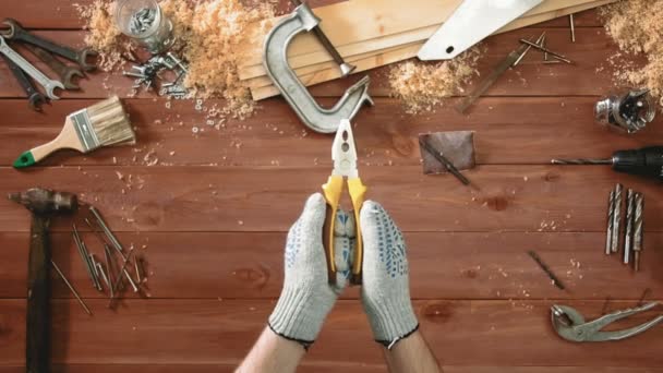 Pohled shora řemeslník ruce zobrazeno kleště v akci — Stock video